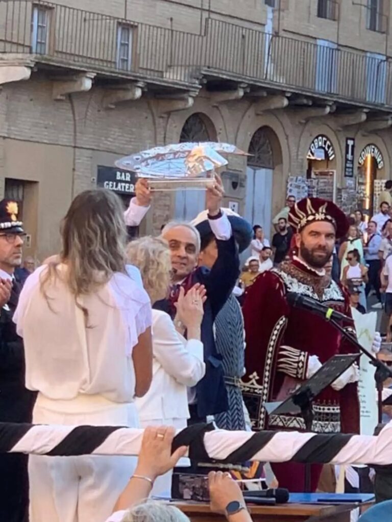 Cerimonia di presentazione in Piazza del Campo : Il momento della cerimonia pubblica in cui l'opera del Masgalano viene sollevata DAL PRIORE e mostrata alla piazza, alla presenza delle comparse in costume storico e delle autorità